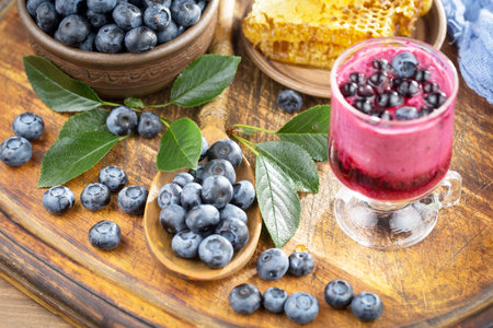 Blueberry smoothie with fresh berries and honey on a wooden backgroundの写真素材