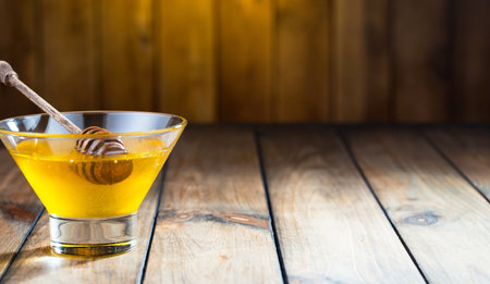 Honey in a glass on a wooden background. Copy space.の写真素材
