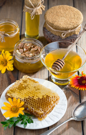 Honey in a jar and honeycombs on a wooden backgroundの写真素材
