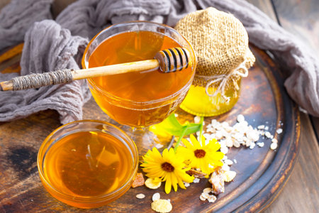 fresh honey in a glass bowl and flower on a wooden backgroundの写真素材