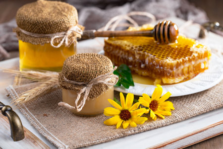 Honey in a jar and honeycombs on a wooden backgroundの写真素材