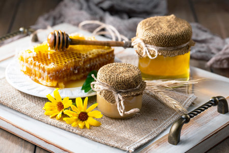 Honey in a jar and honeycombs on a wooden backgroundの写真素材