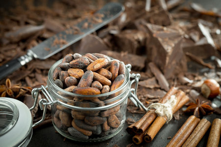 Chocolate and cocoa beans in a glass jar. Selective focus.の写真素材
