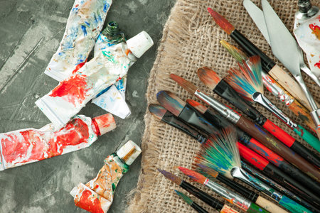 Paintbrushes, paints and palette on grey table, flat layの写真素材