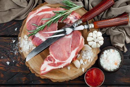 Raw meat with spices in a composition with kitchen accessories.