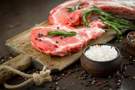 Raw meat with spices in a composition with kitchen accessories.の写真素材