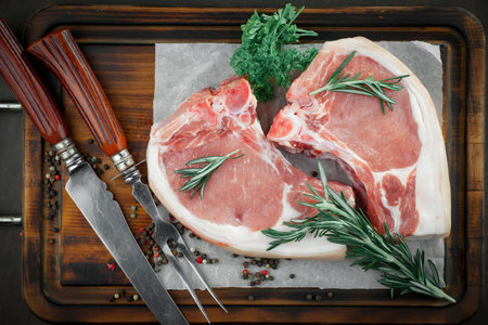 Raw meat with spices in a composition with kitchen accessories.