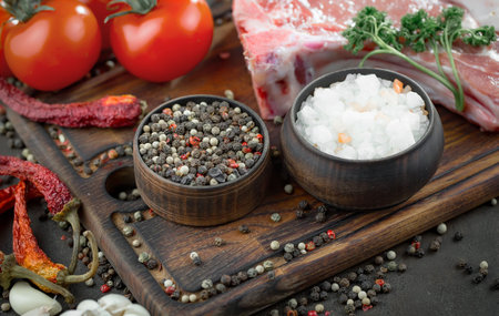 Raw meat with spices in a composition with kitchen accessories.
