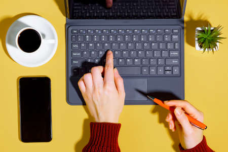 Female hands with items for doing business on a bright colored backgroundの写真素材
