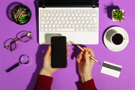 Female hands with items for doing business on a bright colored backgroundの写真素材