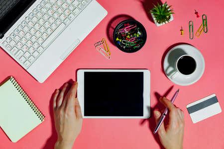 Female hands with items for doing business on a bright colored backgroundの写真素材