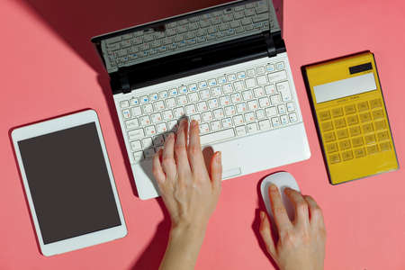 Female hands with items for doing business on a bright colored backgroundの写真素材