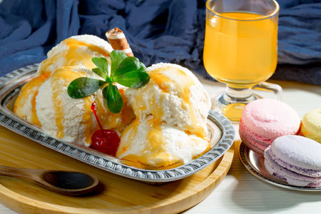 Creamy vanilla ice cream with cherry and mint on a plateの写真素材