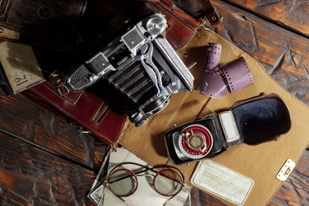 Old camera and other vintage objects on a wooden table. Top viewの写真素材
