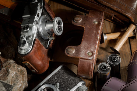 Vintage camera with film and leather case on a wooden background.