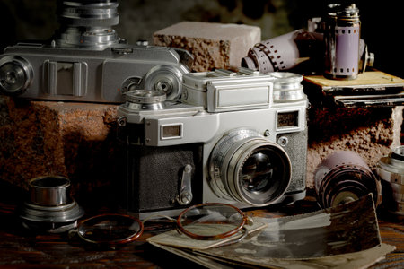 Vintage camera on a wooden table with old photos in the backgroundの写真素材