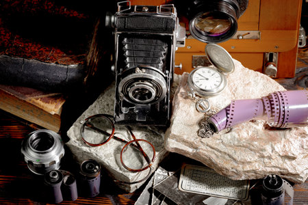 Vintage camera, lens and other items on a dark background.の写真素材