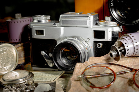 Vintage camera, old photos and other objects on the table.
