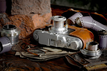 Old camera on the background of old photos. Photographed in the studio