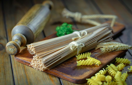 raw pasta on the wooden table, food close-up, selective focusの写真素材