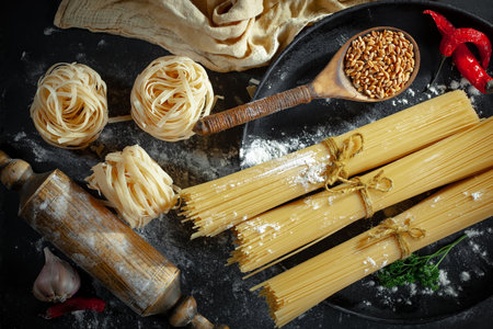 Variety of types and shapes of Italian pasta with ingredients for cookingの写真素材