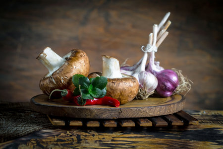 Fresh champignons and garlic on a wooden board, rustic styleの写真素材