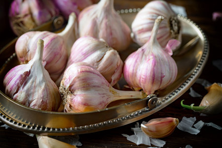 garlic on a metal tray on a wooden background. tinting. selective focusの写真素材