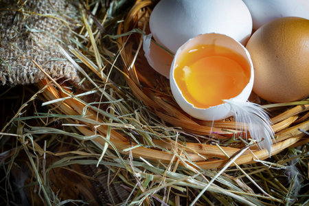 Eggs in a basket with straw on a wooden background.の写真素材