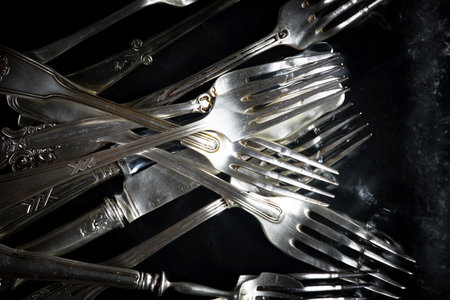 Vintage silver cutlery on black background. Selective focus.の写真素材