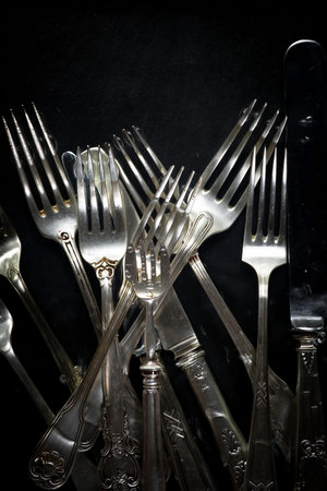 Vintage silverware on a black background. Selective focus.