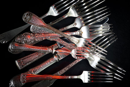 Vintage silverware on a black background. Selective focus.