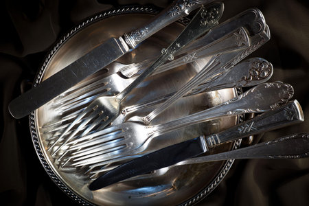 Vintage silverware and cutlery on a metal plate.