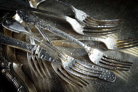 Old silver cutlery on a dark background. Toned.