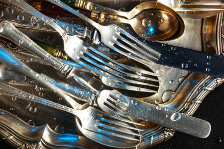 Close up of a pile of cutlery on a plate.の写真素材