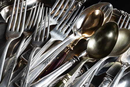 Vintage silverware on a black background. Selective focus.