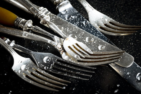 Old silverware on a black background with water drops. Toned.の写真素材