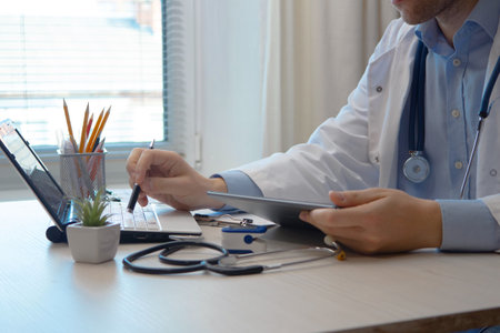 Doctor working on tablet computer at office desk. Medical and healthcare concept.の写真素材