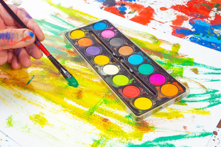 palette with watercolors and paintbrush on a white backgroundの写真素材