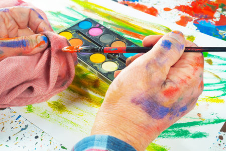 Close-up of a child's hands painting with watercolorsの写真素材