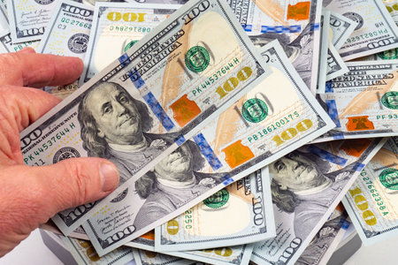 Hundred dollar bills in the hands of a man close-upの写真素材