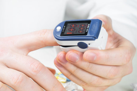 Close up of hand measuring blood sugar level with digital glucometer