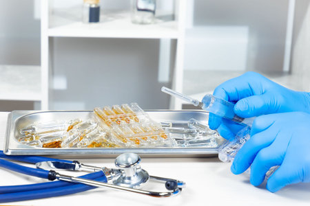 Close-up of the hands of a doctor in blue gloves holding a syringe