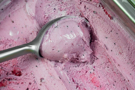 Scoops of strawberry ice cream in a glass bowl with spoonの写真素材