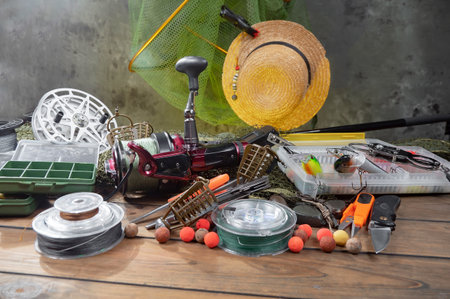 fishing tackle on a wooden table in the background of a gray wallの写真素材