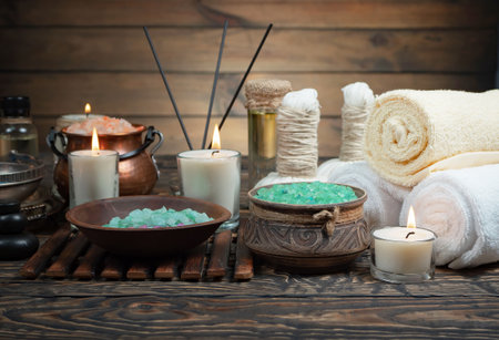 Spa still life with sea salt, candles and towels on wooden backgroundの写真素材
