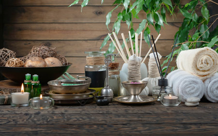 Spa still life with herbal compress balls and candles on wooden backgroundの写真素材