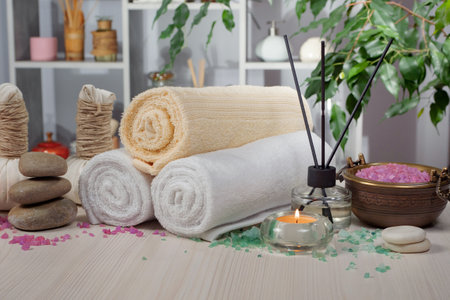 Spa still life with towels, candles and sea salt on wooden tableの写真素材