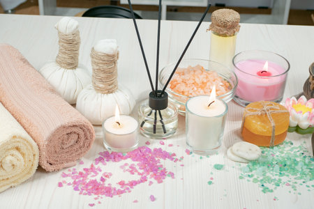 Spa and wellness setting with towels, candles and salt on wooden backgroundの写真素材