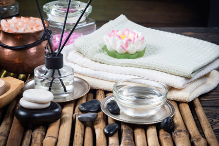 Spa still life with lotus flower, candle and towel on wooden backgroundの写真素材