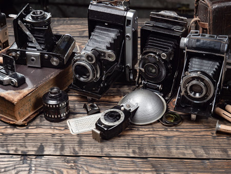 Old camera on an old wooden table in a photo studio. Close-up